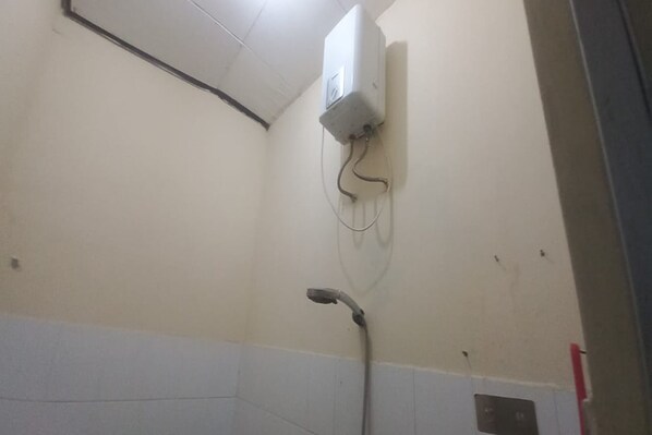 A bathroom with a shower, a wall-mounted heater, and a visible electrical outlet. - OYO 95110 Eksklusif Gueshouse Syariah (Kauman)