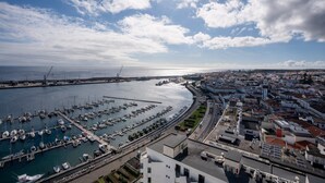 A coastal cityscape with a marina, buildings, and a clear sky. - Solmar Sunset Place | Marina View (Ponta Delgada)