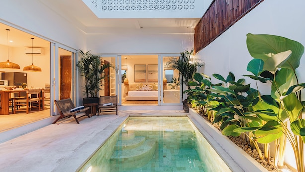 A modern house with a swimming pool, a dining area, and a living room with a sofa and a TV. - Villa Arlo Canggu (Cemagi)