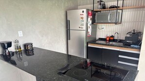 A compact kitchen with a built-in stove, a refrigerator, and a microwave.