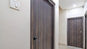 A hallway with two wooden doors, each marked with a number. - Hotel O Chinar Park Kolkata Zapper (Barasat)