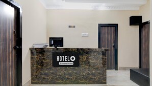 A hotel reception desk with a marble top, a reception sign, and a reception area. - Hotel O Chinar Park Kolkata Zapper (Barasat)