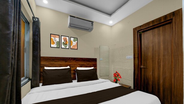 A hotel room with a large bed, a wooden headboard, an air conditioning unit, and a wooden door. - Collection O Bhel Piplani Bhopal (Bhopal)