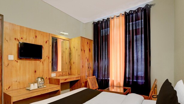 Une chambre d’hôtel avec un mur en bois, un téléviseur à écran plat, un lit, un bureau et une chaise.