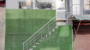 Un escalier avec une rampe métallique menant à l’entrée d’un bâtiment.