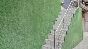 Un escalier avec une rampe métallique menant à l’entrée d’un bâtiment.