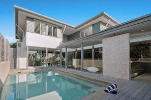 A modern house with a swimming pool, large windows, and a covered patio area. - Dune House (Tweed)