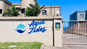 En bygning med et skilt, der viser "Aqua Tides", og et logo af en bølge.
