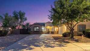 A residential property with a driveway, a gated entrance, and a well-maintained lawn. - Swim, Golf, Grill & Chill! Surprise Group Getaway (Surprise)