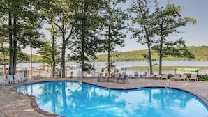 A swimming pool with lounge chairs and a view of a lake. - Walk to Big Boulder Mtn & Lake, Home w/ Hot Tub! (Lake Harmony)