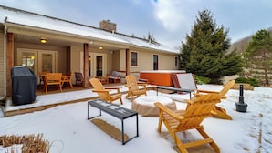 A covered outdoor seating area with Adirondack chairs and a table, a hot tub, and a grill. - Walk to Big Boulder Mtn & Lake, Home w/ Hot Tub! (Lake Harmony)