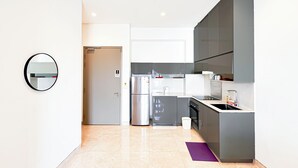 Una cocina moderna con electrodomésticos de acero inoxidable, horno empotrado y un lavamanos.