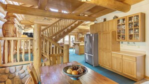 A wooden interior with a dining table, a bowl of fruit, a refrigerator, and wooden cabinets. - 5 Mi to Purgatory Resort, Mtn-View Family Cabin! (Durango)