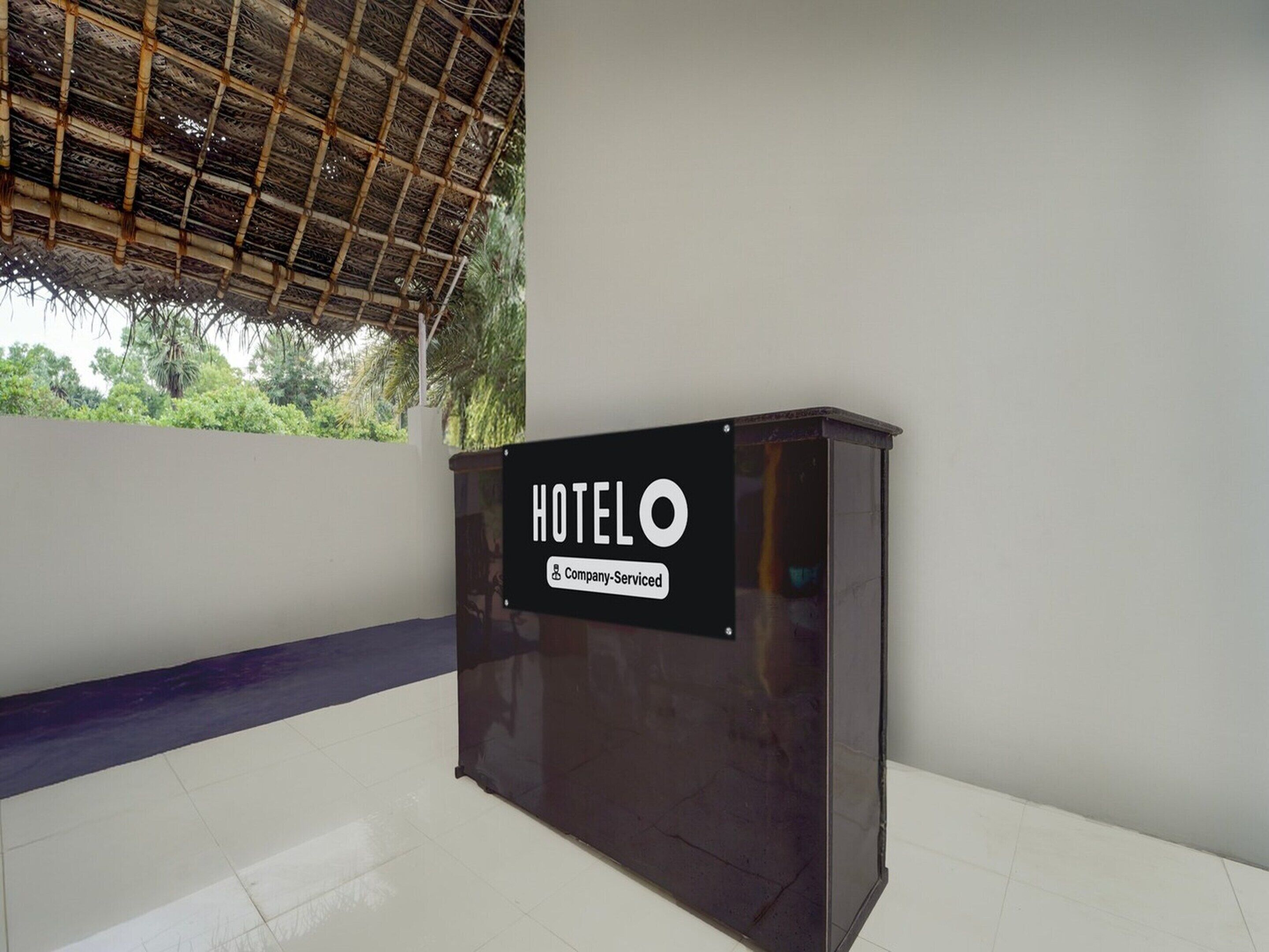 A hotel reception desk with a sign indicating it is company-serviced.