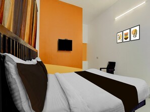 A hotel room with a bed, a television on the wall, and a chair. - Hotel O Auroville Bird Sanctuary Chennai (Vanur)
