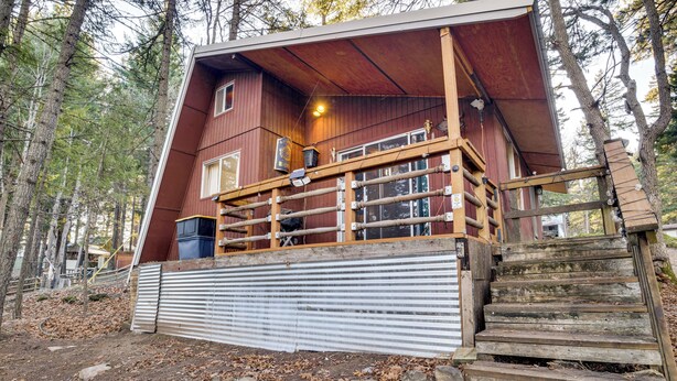 A cabin with a wooden deck, a covered porch, and a stone staircase. - Fire Pit & Water Views! Woodsy Tygh Valley Retreat (Tygh Valley)
