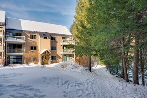 A multi-story building with a snow-covered roof and a small entrance. - Close to Smuggs Lifts! Cozy Mountain-View Condo (Jeffersonville)