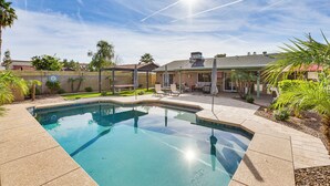 A swimming pool with a patio area, surrounded by palm trees and a fence. - Private Outdoor Oasis! Chandler Home, 5 Mi to Dtwn (Chandler)