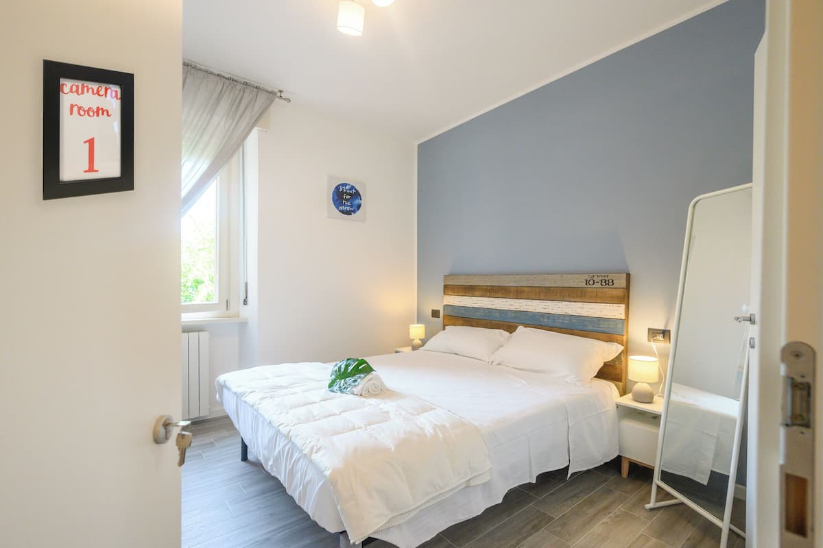 Une chambre à coucher comprenant un lit, des tables de chevet, un miroir et un panneau indiquant « chambre de contrôle n° 1 ».