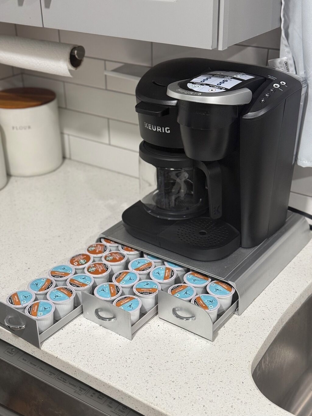 Een Keurig koffiezetapparaat met een peilhouderset op een keukentrap.