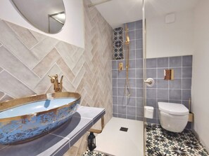 Chuveiro, secador de cabelo, toalhas de banho, papel higiênico