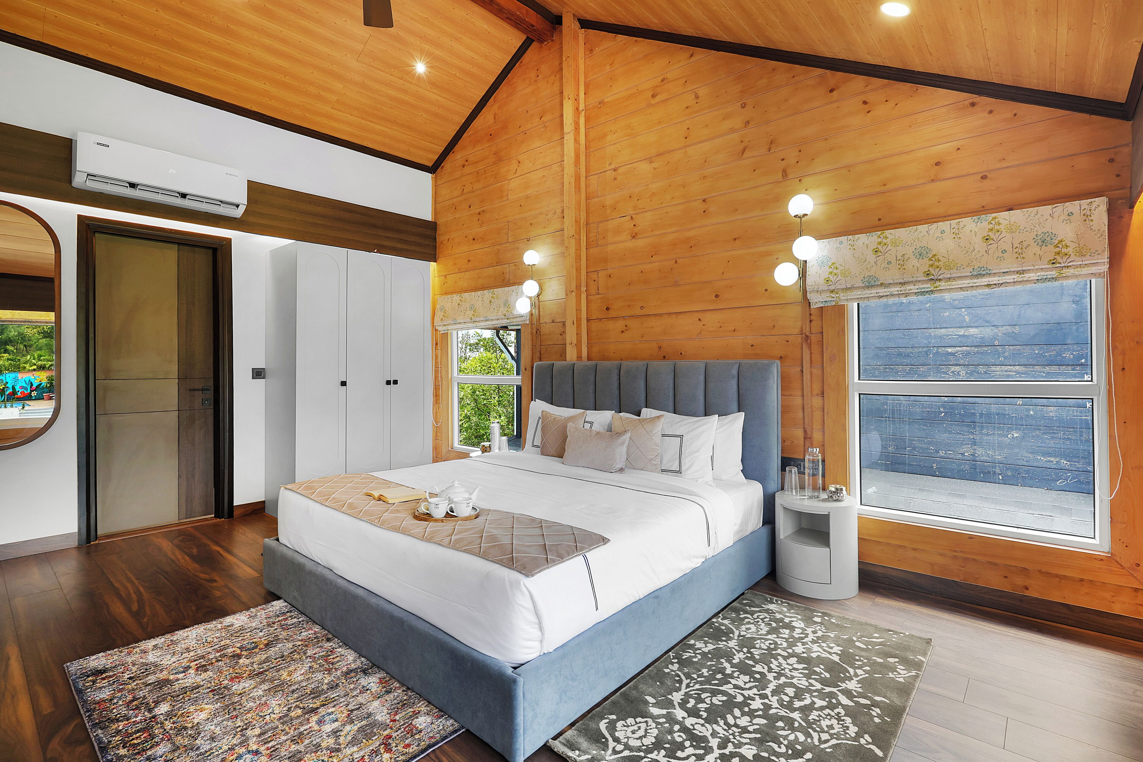 Quarto com cama grande, teto de madeira e janela com vista.