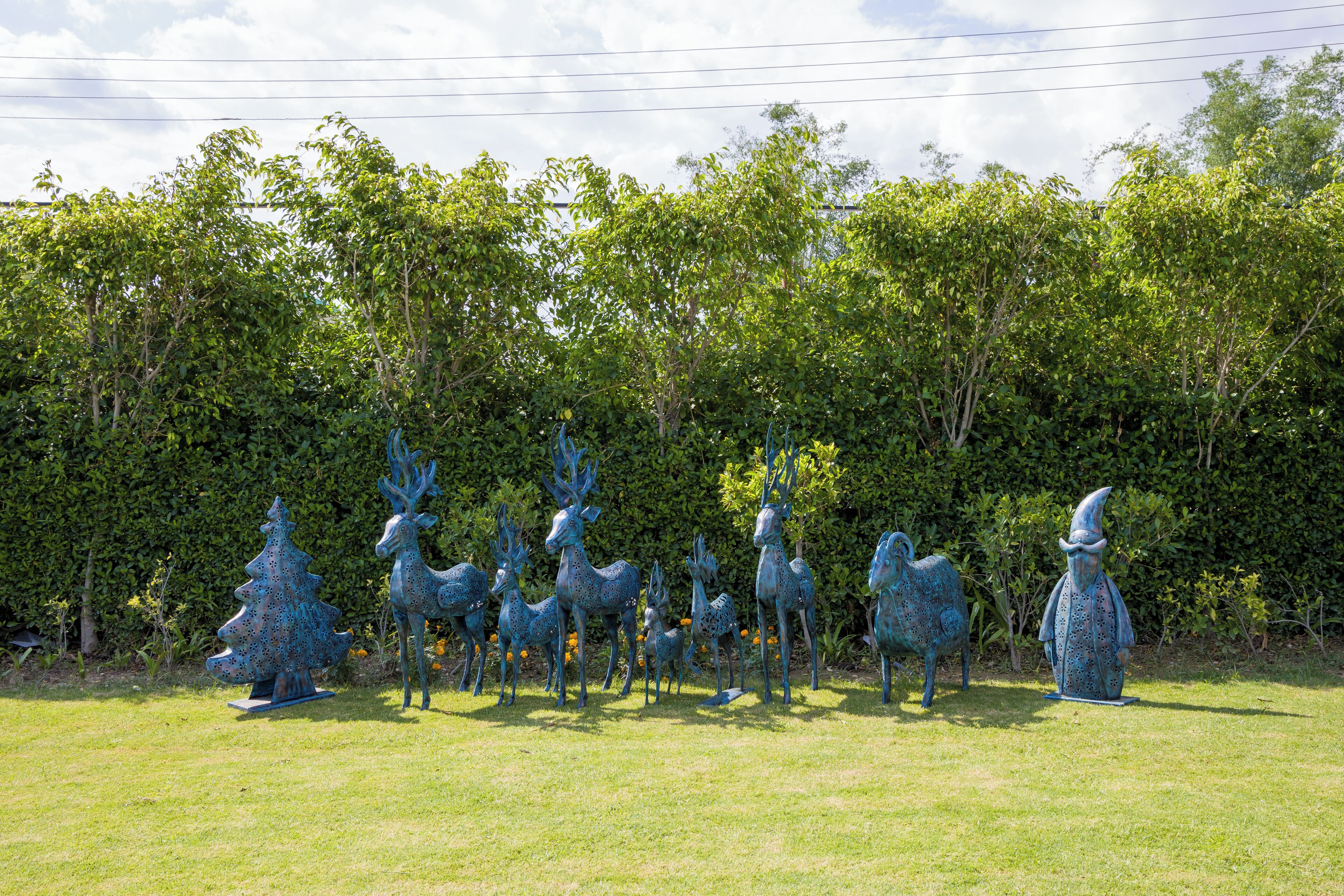 Un jardin de sculptures où l’on peut admirer diverses sculptures d’animaux et d’arbres, le tout installé sur une pelouse verdoyante.
