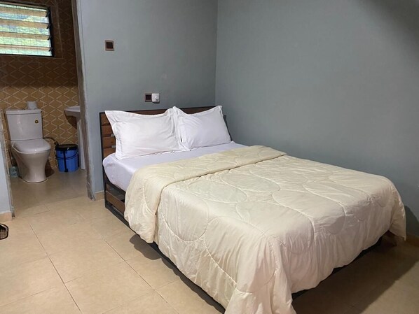 A bedroom with a bed, a toilet, and a window. - Bamboo river resort (Wli)