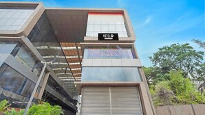 A modern hotel building with a prominent 'HOTEL' sign, a large glass facade, and a closed shutter at the entrance.