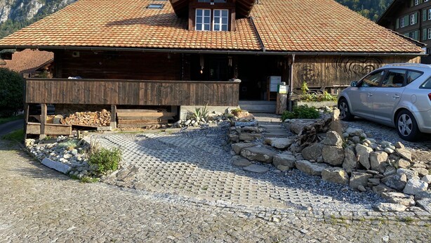 A rustic mountain lodge with a tiled roof, wooden exterior, and a car parked in front. - Lake view Chalet  , Därligen (Interlaken-Oberhasli)