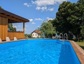 En säsongsöppen utomhuspool och solstolar