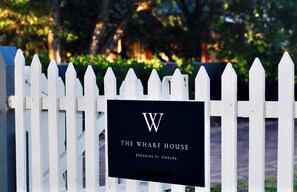 A white picket fence with a sign that reads "The Wharf House" and "Brookings St. Goolwa". - The Wharf House Goolwa (Alexandrina Council)