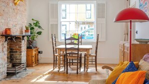 Un coin repas avec un mur en briques, une table en bois et des chaises.