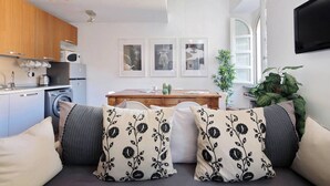 A modern living room with a sofa, a coffee table, and a kitchen in the background. - Historic Center Rome Colosseum 2BR 2BA Metro (Roma)