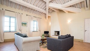 A spacious living room with two sofas, a fireplace, and a television. - Apartment Cipresso-Cignella Resort in Tuscany (Siena)
