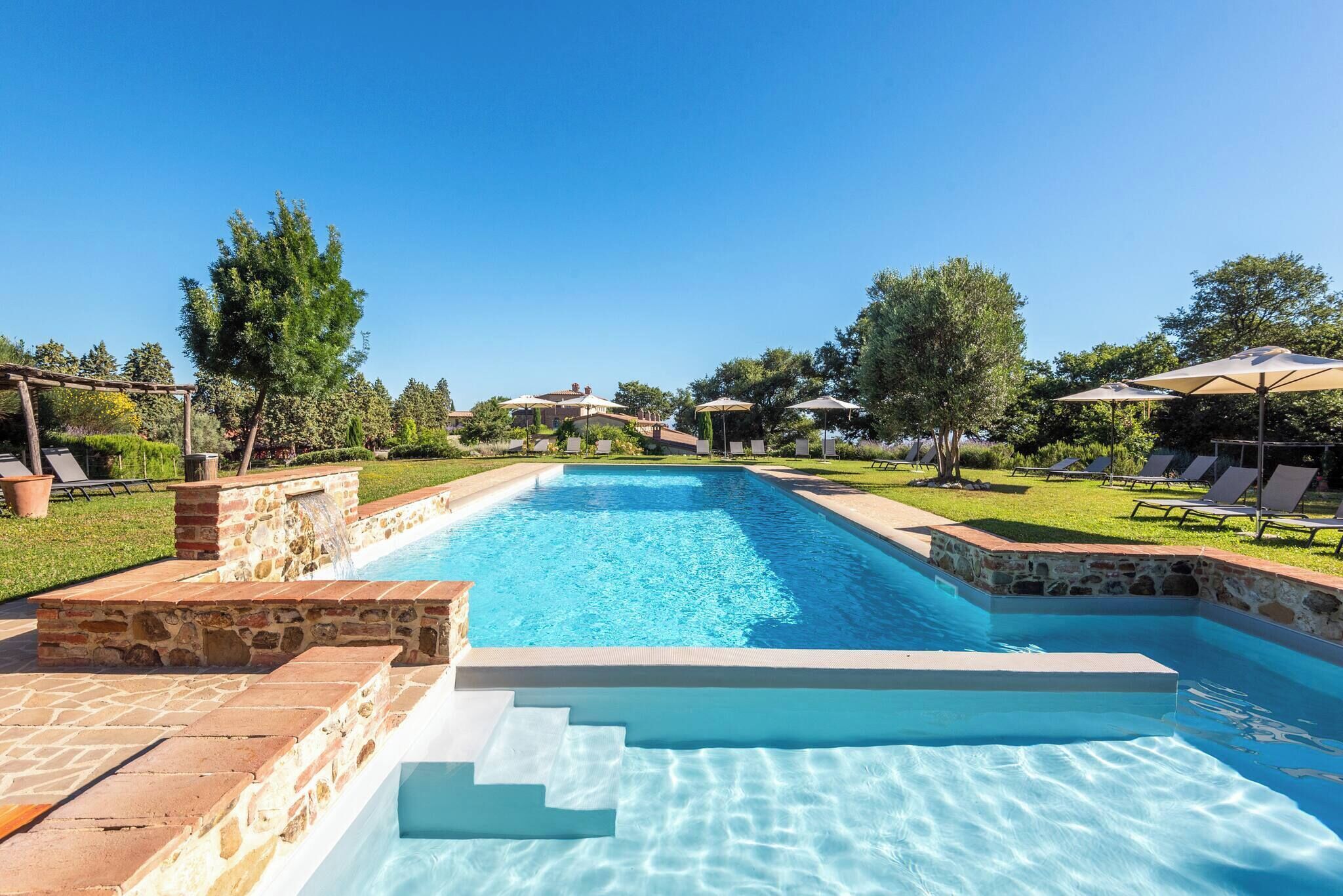 Ein rechteckiger Swimmingpool mit Steinbord und Stufen zum Wasser.