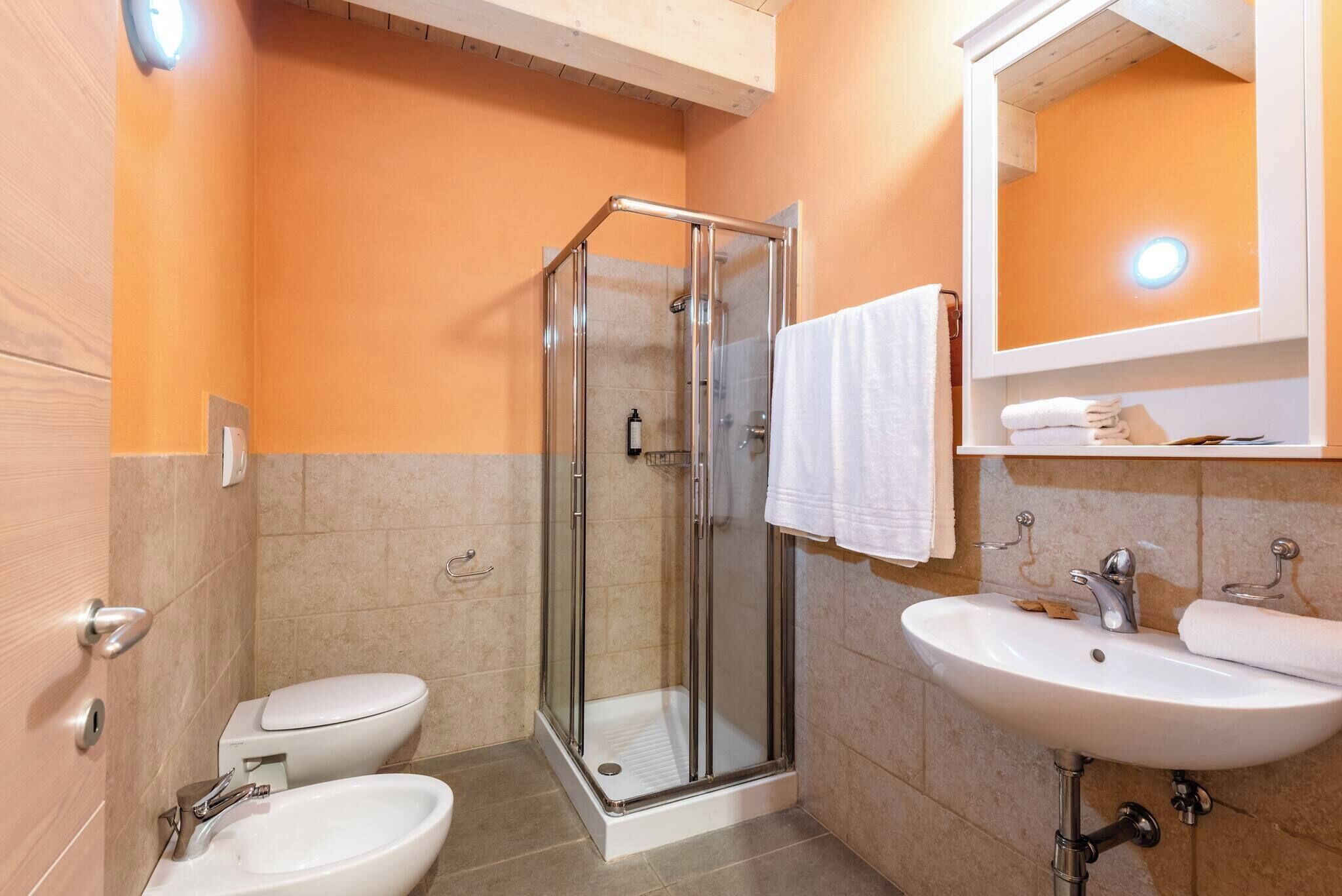 A bathroom with a glass shower enclosure, a white sink, and a toilet.