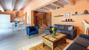 A modern living room with a sofa, a coffee table, and a staircase leading to another level. - Villa Pesca amazing House in the heart of Tuscany (Tuscany City)