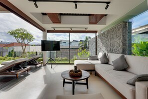 Villa, balkon, uitzicht op zwembad | Woonruimte | Een 55-inch ledtelevisie met digitale zenders en Netflix