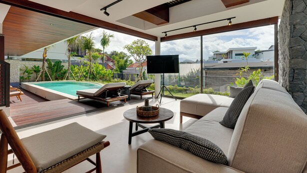 A modern living room with a pool, outdoor seating, and a large TV. - Villa Pasisi 11 - Canggu (Canggu)