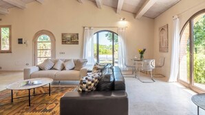 Un salon spacieux avec un canapé, une table basse et un coin repas avec des chaises.