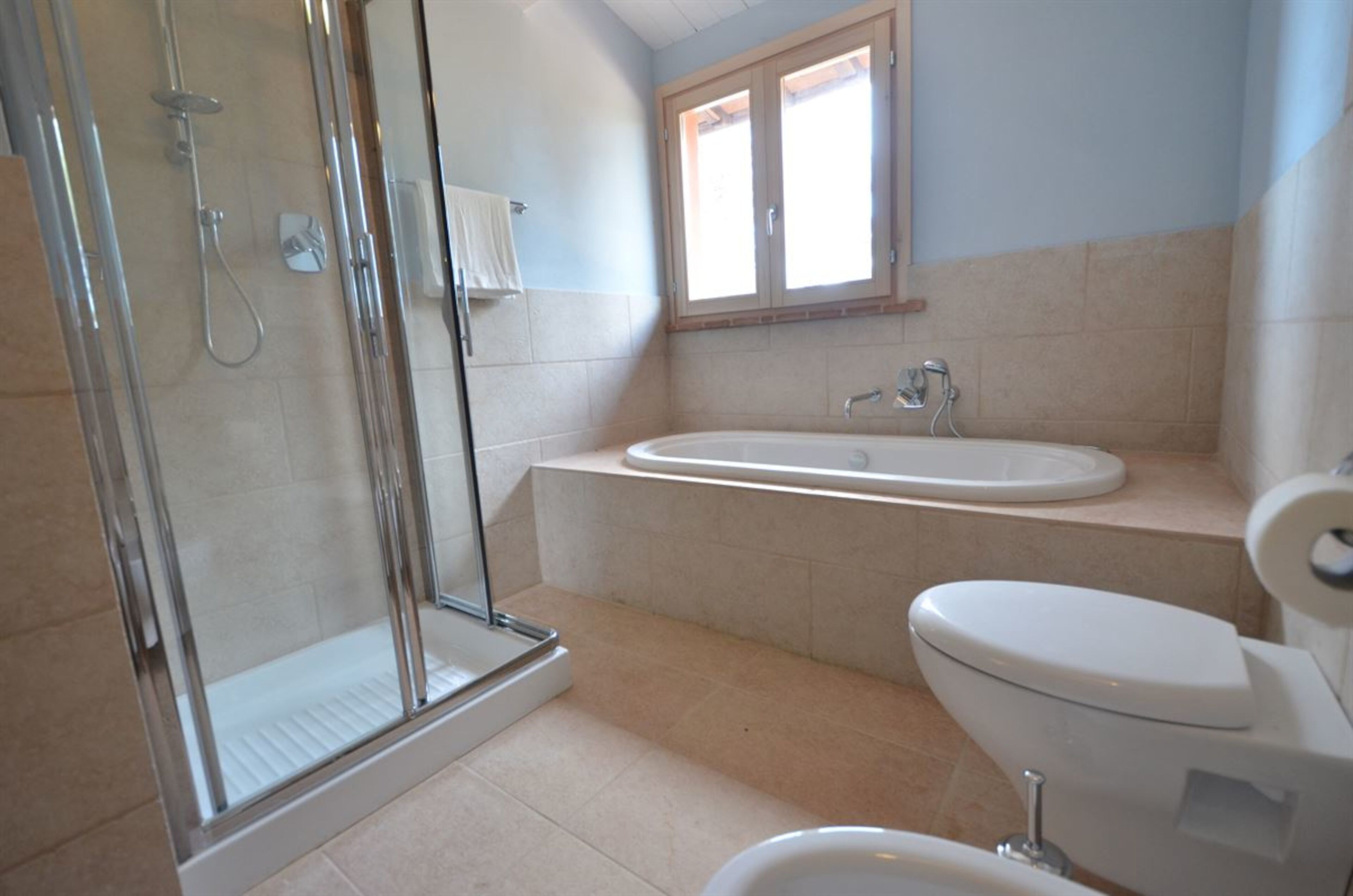 Ein Badezimmer mit Duschkabine, Badewanne, Toilette und Waschbecken.