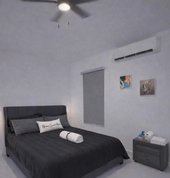 Ein Schlafzimmer mit Bett, Deckenventilator, Klimaanlage, Nachttisch und zwei Wandbildern.