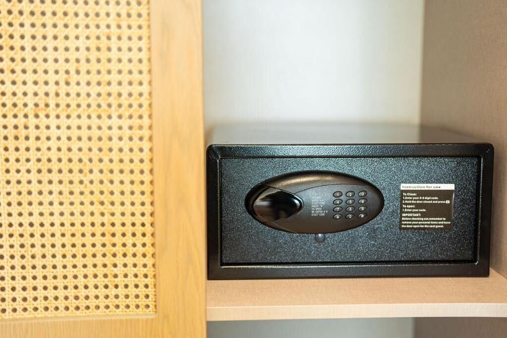 A black electronic device with a keypad and a label with instructions on a wooden surface.
