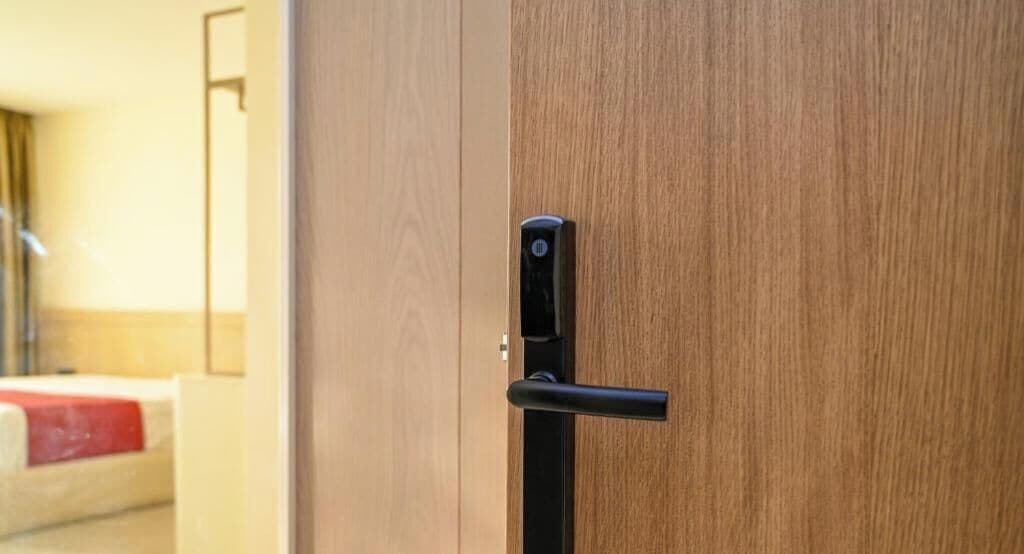 Une porte en bois avec une poignée noire et un trou de serrure.