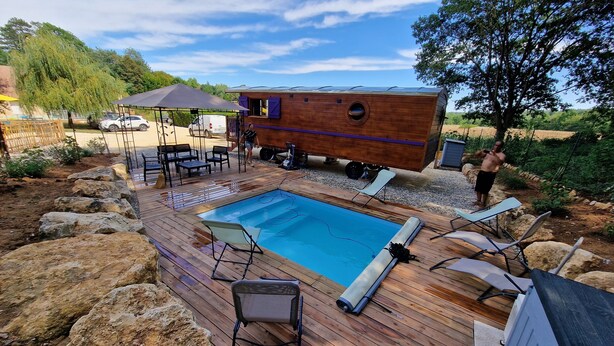 A wooden deck with a swimming pool, lounge chairs, and a small wooden structure with purple shutters. - Charming Holiday Home in Journiac with Pool Access (Journiac)