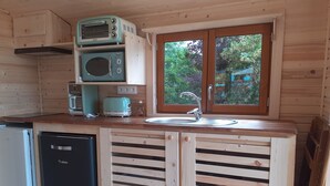 A compact kitchen with wooden cabinetry, a built-in microwave, a toaster, and a sink. - Charming Holiday Home in Journiac with Pool Access (Journiac)