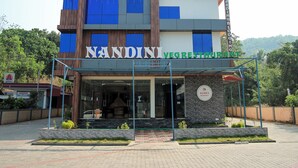 A multi-story building with signage for 'NANDINI VEG RESTAURANT' and 'SUDEV RESIDENCY BOARDING & LOPGING'. - Sudev Residency (Mangaluru)