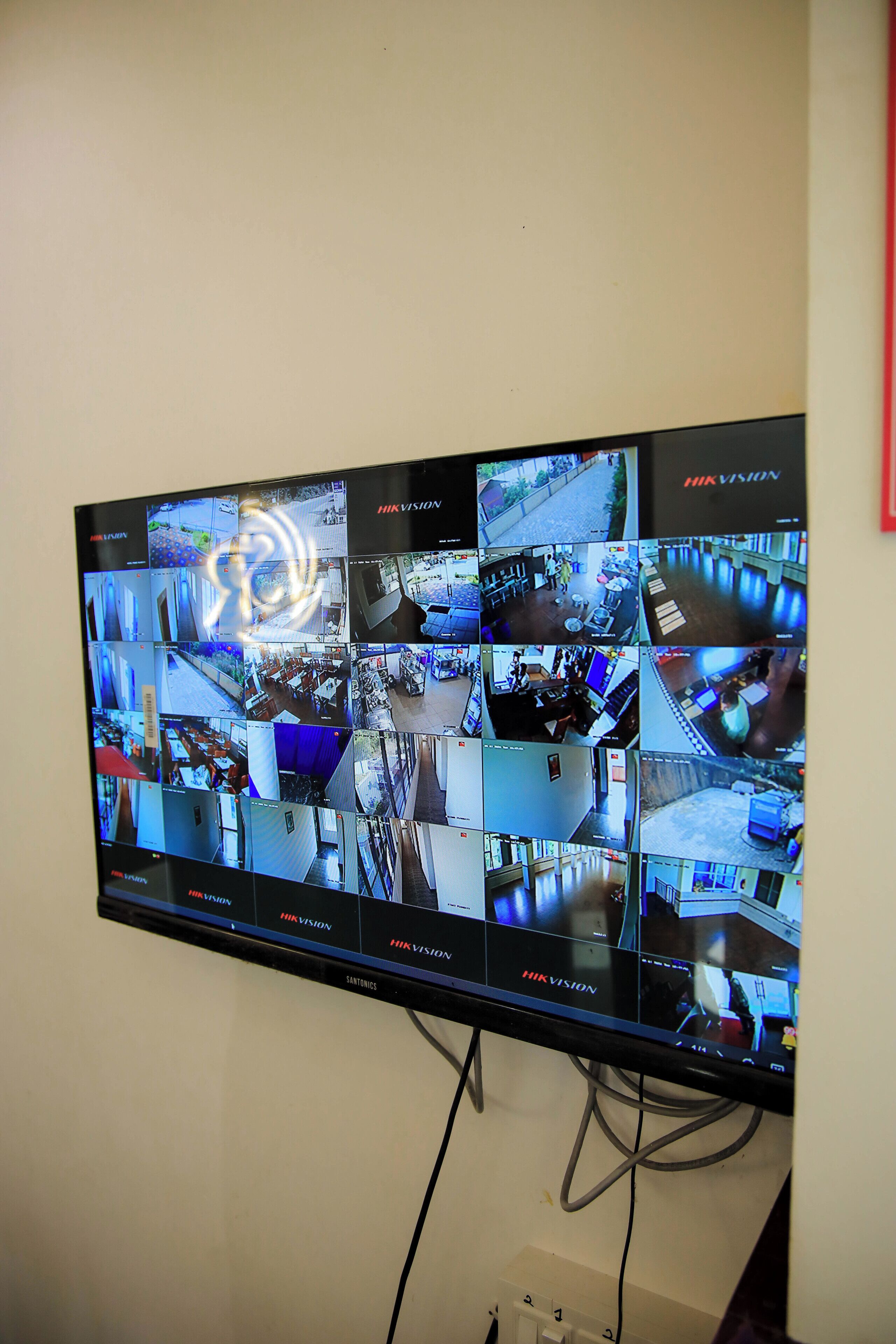 A multi-camera security monitor displaying various indoor scenes.