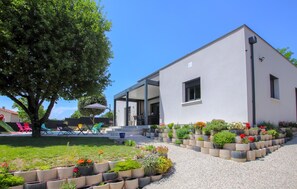 A modern building with a covered patio area, outdoor seating, and a garden with raised planters. - Nice home in Montboucher sur Jabron (Montboucher sur Jabron)